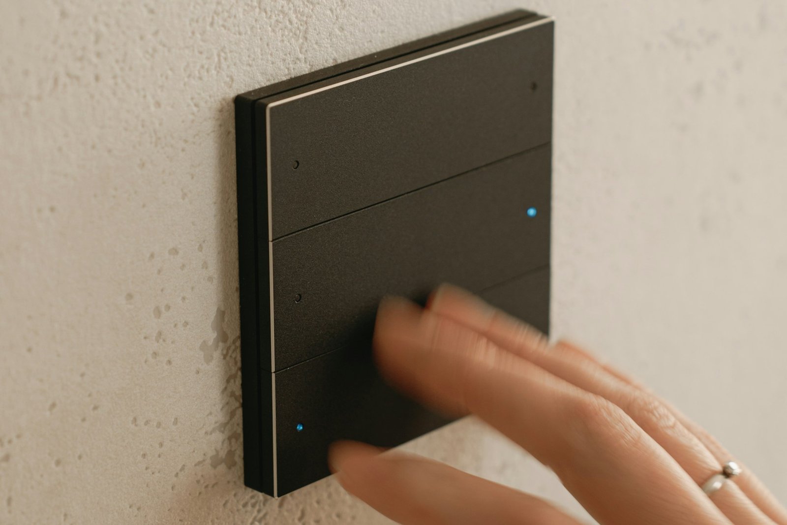 Hand bedient einen Drehdimmer an der Wand